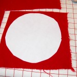 "Rough' cut fusible circle ironed to 1 layer of red wool background