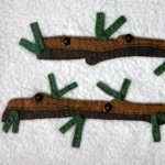 Close up of rough log yule tree branches, 'needles' and buttons for hanging ornaments 